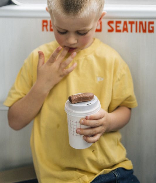 Child traveling on Island Direct heading to Waiheke Island holding a hot chocolate
